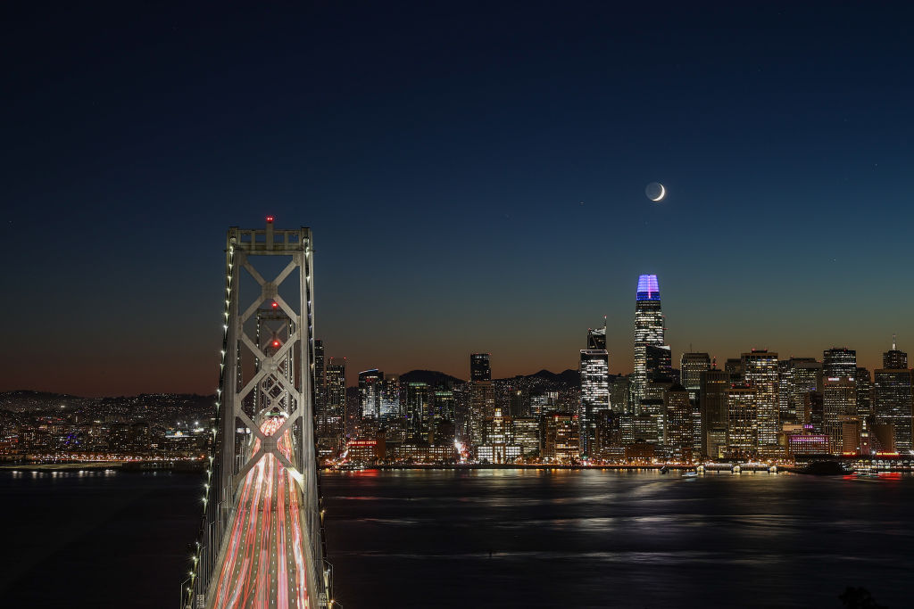 Le croissant de lune se couche derrière la Salesforce Tower après le coucher du soleil à San Francisco.