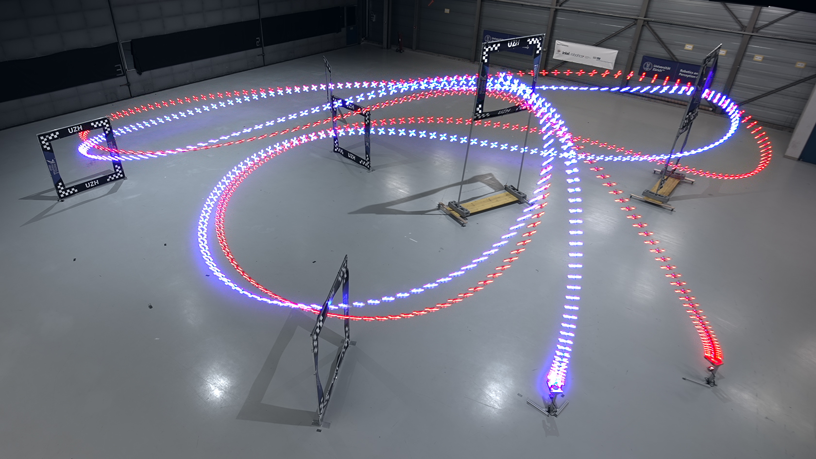 Une longue exposition de drones passant à travers des portes dans un entrepôt.